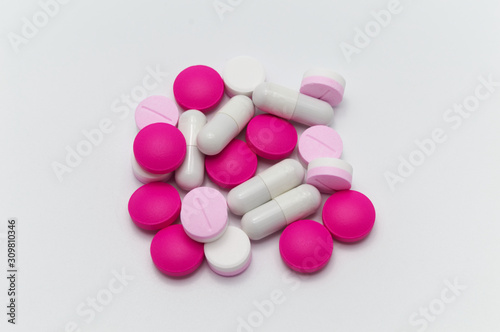 Prescription drugs, pills, capsules and tablets of different colors all mixed in. On white background.