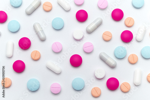 Different colorful pills or supplements for the treatment and health care on a white background.