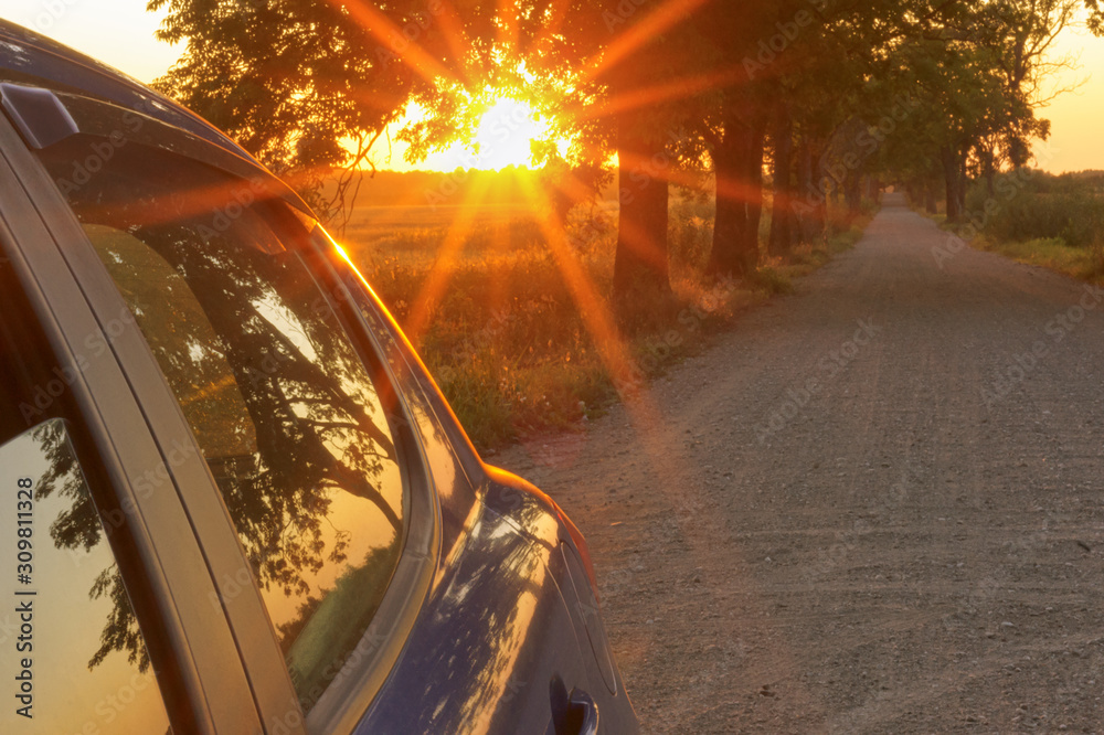 The sun's rays blue cars on the road. The sunset and the car.
