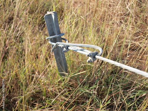 Anchor and Guy Wire for stable electricity pole On the grass and ground background.Selective focus