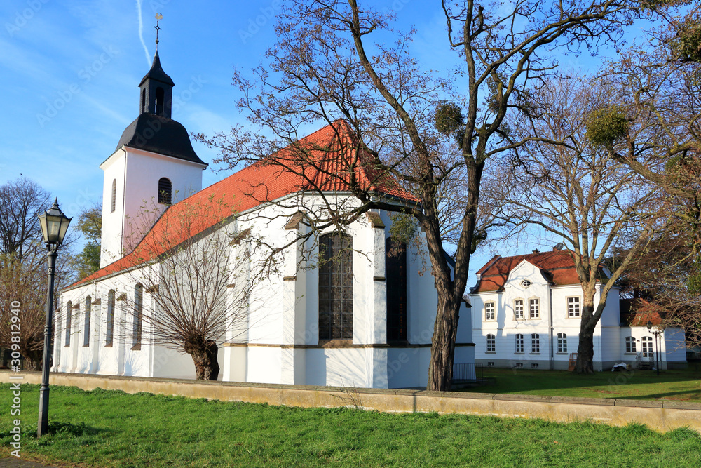 Dorfkirche in Friemersheim mit dem historischen Lehrerhaus im Hintergrund
