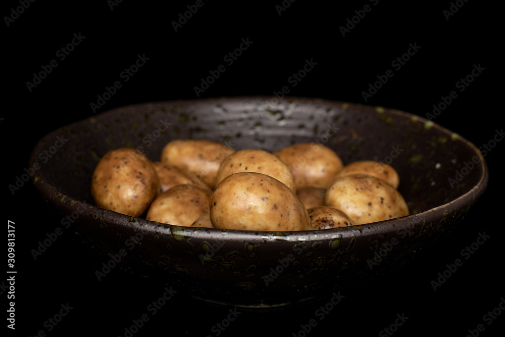 Lot of whole tiramisu brown almond nut in glazed bowl isolated on black glass Lot of whole tiramisu brown almond nut in glazed bowl isolated on black glass