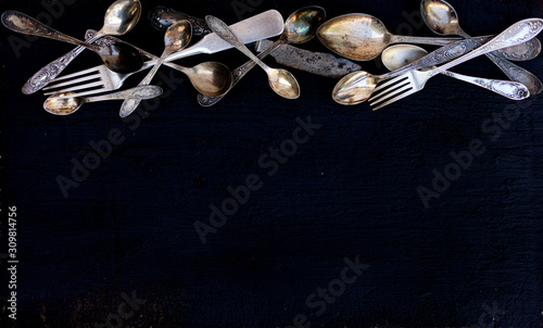 Vintage cutlery - spoons, forks and knives on an old wooden background.