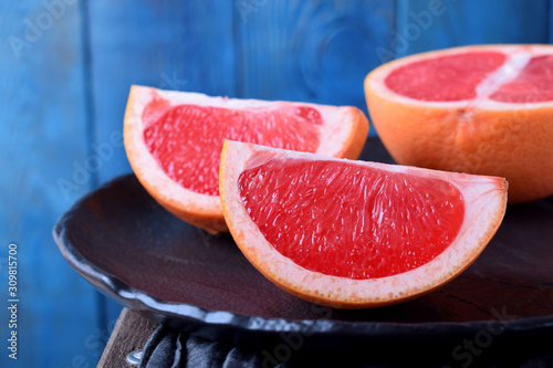 Slices of red grapefruit on the black plate