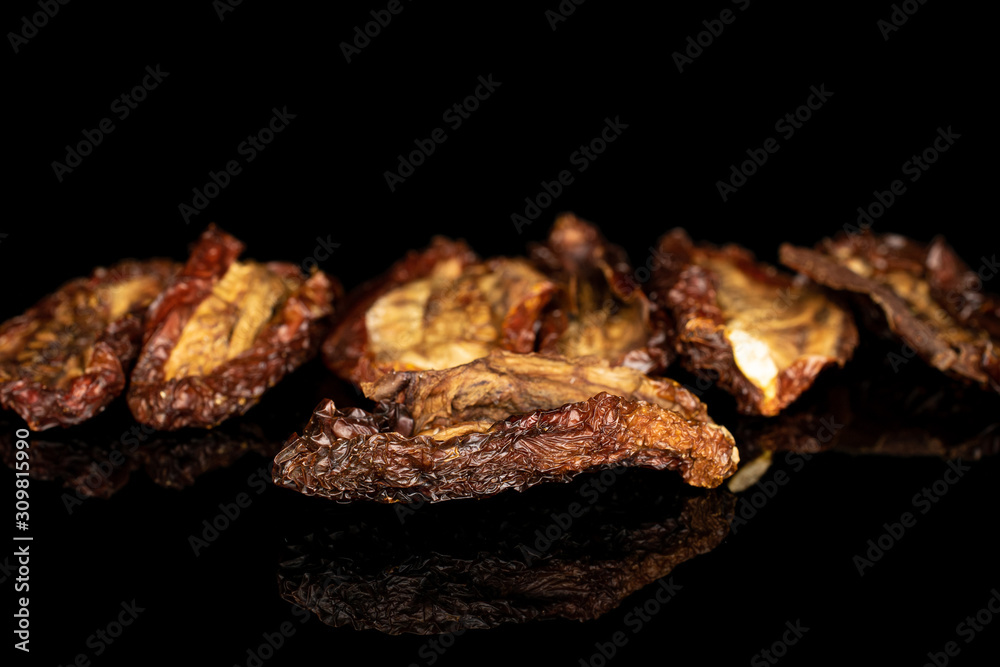 Group of seven whole dried red tomato piece isolated on black glass Group of seven whole dried red tomato piece isolated on black glass