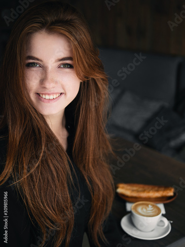 Wallpaper Mural Cute redhead woman woman with adorable smile sitting in cozy city cafe enjoying free time coffee break with cappuccino and dessert Torontodigital.ca