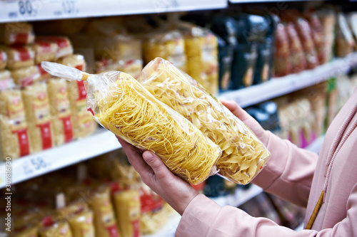 Woman buyer with package pasta in shop