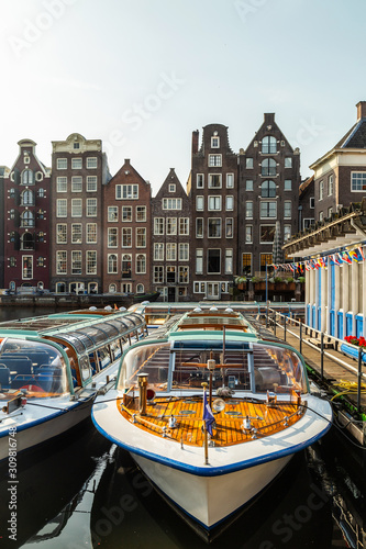 Amsterdam boats on the canal in Damrak area © hungry_herbivore