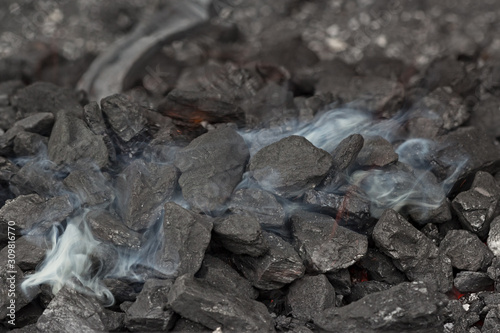Φωτογραφία Smoke over the coals of a blacksmith's brazier where the iron horseshoe is annea