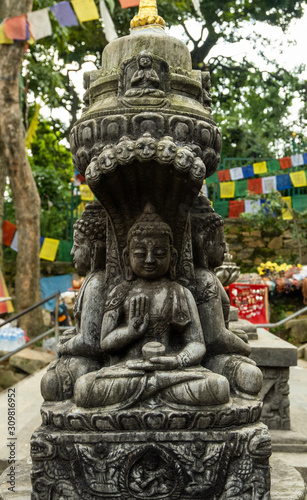 Ancient carved stone pillar with the image of a sitting Buddha and are decorated with traditional Buddhist patterns.