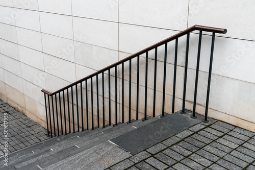 Street staircase with railing on the background of a gray wall.
