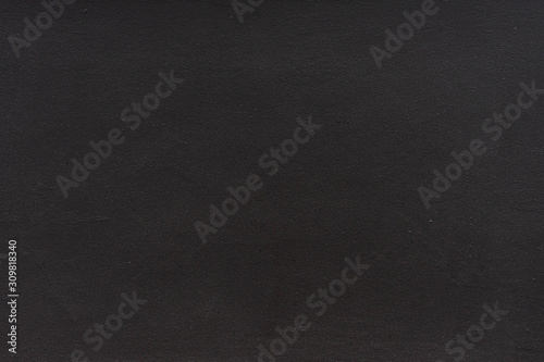 Plain black stucco background. The texture of the dark wall.