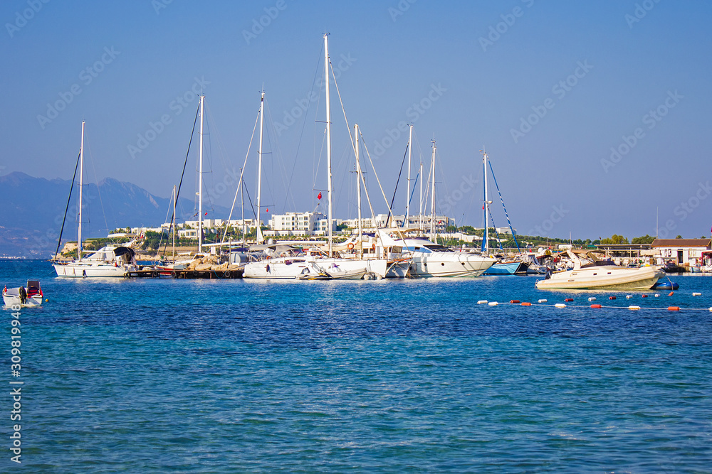 Beautiful white yachts, ships and sailing boats moored on the shores of blue Aegean sea near Akyarlar region of Bodrum, Mugla, turkey.