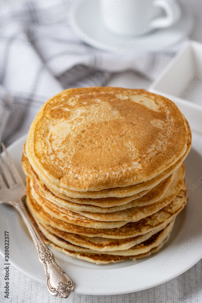 Sweet homemade pancakes on white plate with fork on left side. Sweet homemade pancakes on white plate with fork on left side.
