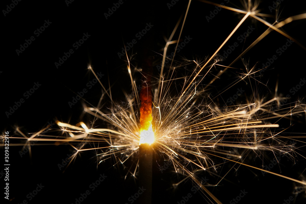 A burning sparkler with black background A burning sparkler with black background