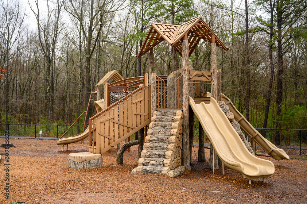 An empty playground on a wet winter day. No people are present to slide or climb on the equipment.