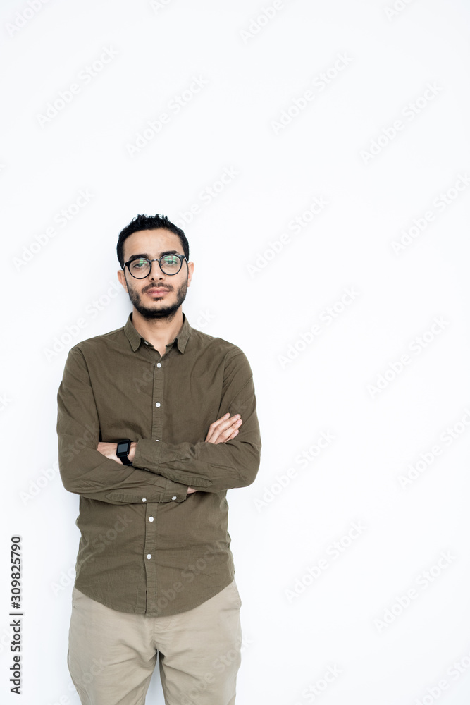 Young serious mixed-race businessman in casualwear looking at you in isolation Young serious mixed-race businessman in casualwear looking at you in isolation