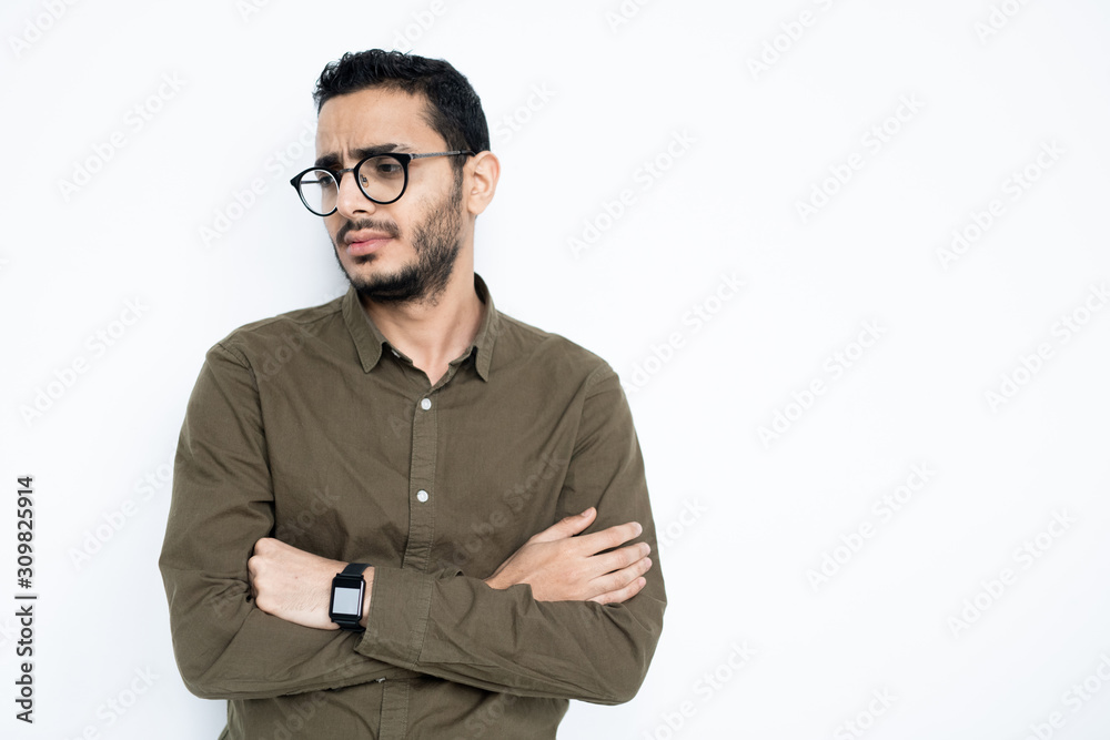 Dissatisfied businessman in casualwear and eyeglasses crossing his arms by chest Dissatisfied businessman in casualwear and eyeglasses crossing his arms by chest