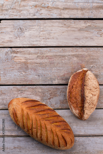 Top view of artisan bread on wooden background. Freshly baked homemade bread. Space for text.