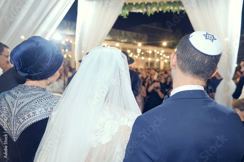 Groom with the bride on a hupa of the Jewish wedding. Rear view. photo