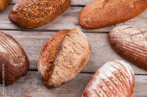 Natural organic bread assortment on wooden background. Delicious artisan bread with crust.