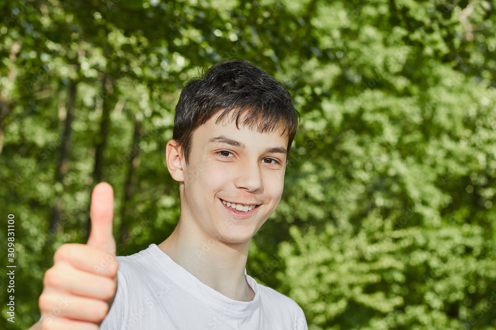 teenager showing thumbs up on background of nature teenager showing thumbs up on background of nature