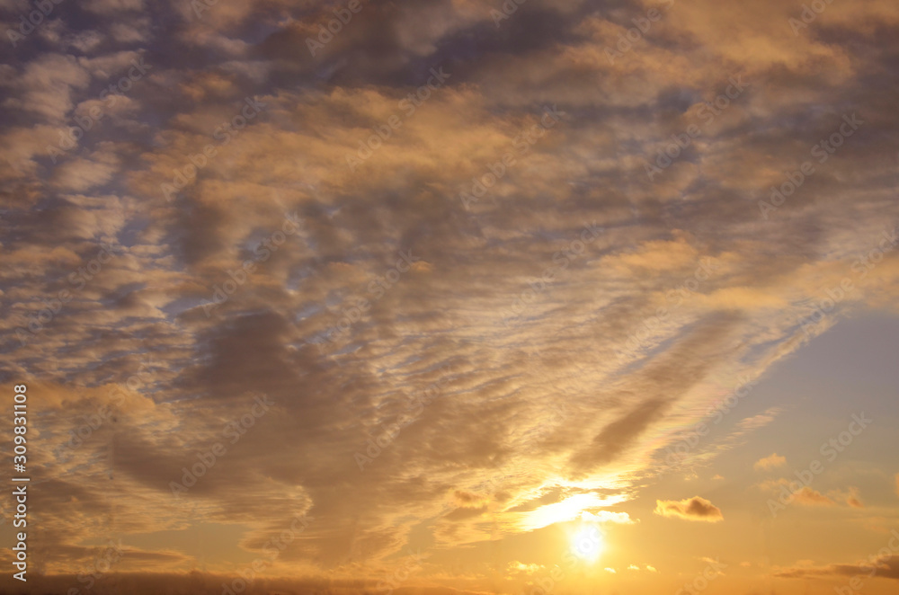 Sky with a bright orange sunset. The natural composition. The setting sun illuminates the clouds. For the background. Sky with a bright orange sunset. The natural composition. The setting sun illuminates the clouds. For the background.