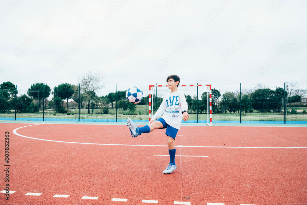 Fototapeta premium Soccer player boy hitting the ball