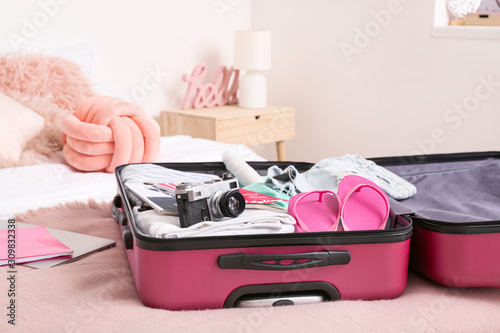 Open suitcase with packed c...