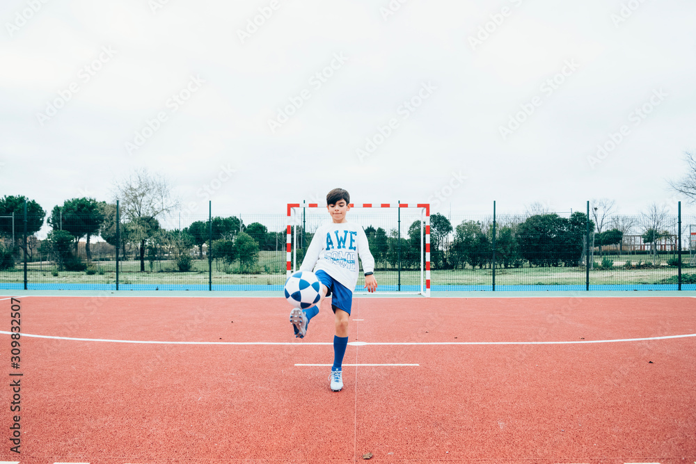 Obraz premium Soccer player boy hitting the ball