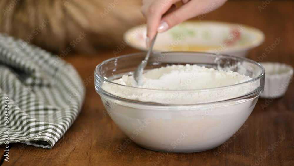 Close up of female hands preparing and knead the dough in bowl. Close up of female hands preparing and knead the dough in bowl.