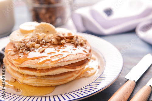 Plate with tasty sweet pancakes on table, closeup