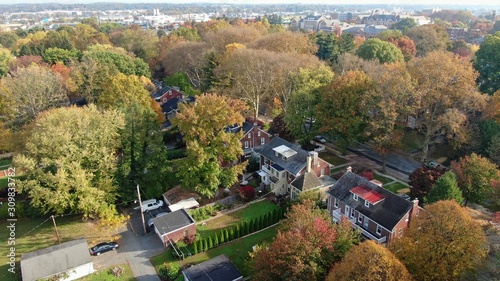 Colorful autumn foliage in suburban area, vintage villas and mansions in residential district, houses hidden in trees, luxury real estate with fancy backyards, aerial view of wealthy neighbourhood