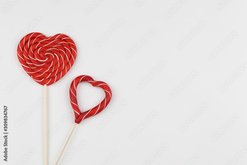 red hearts as lollipop candy. Valentines day minimalist background. red heart, love symbol, space for text concept.