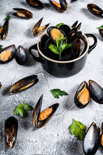 Raw fresh mussels in shells. The concept of cooking seafood. Gray background. Top view