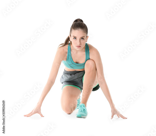 Sporty young woman in crouch start position against white background
