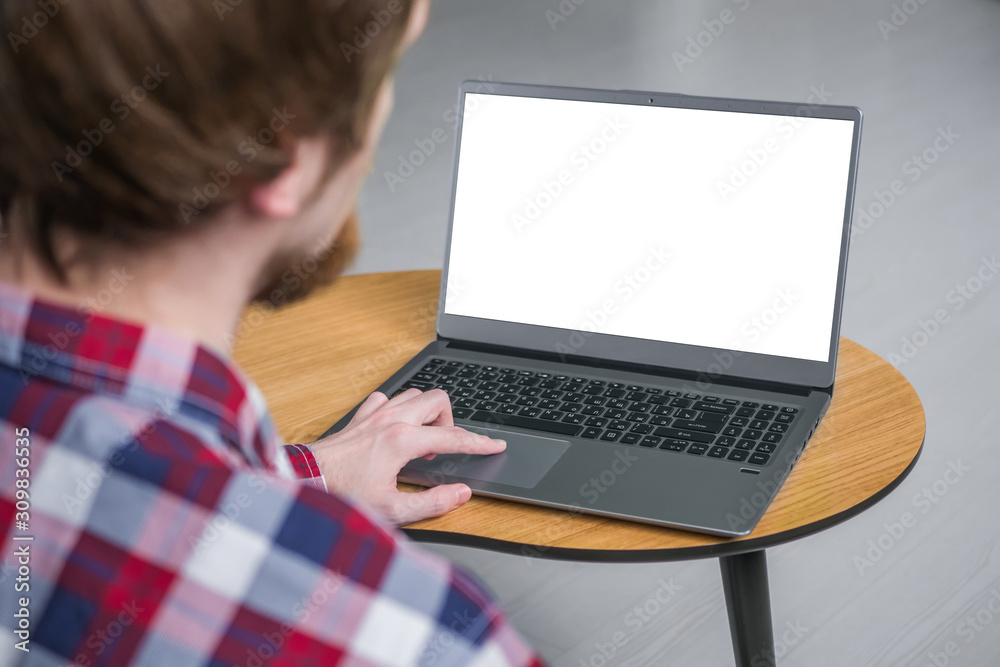 Mockup image of man using touchpad of grey laptop with white blank screen on wooden table in home or office. Mock up, copyspace, freelance workspace, template, entertainment and technology concept Mockup image of man using touchpad of grey laptop with white blank screen on wooden table in home or office. Mock up, copyspace, freelance workspace, template, entertainment and technology concept