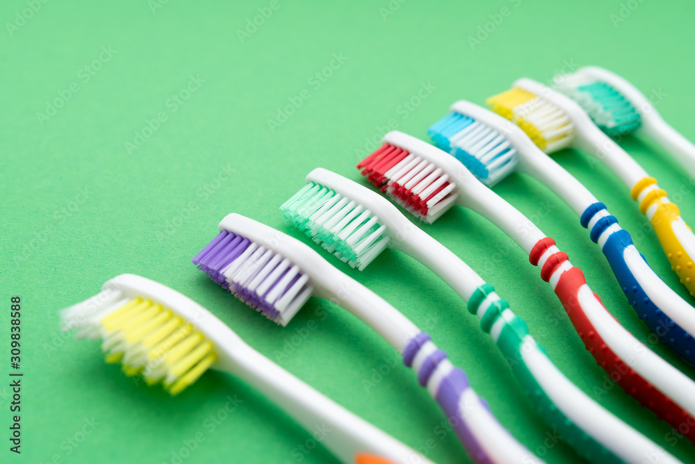 plastic colored toothbrushes on green background plastic colored toothbrushes on green background