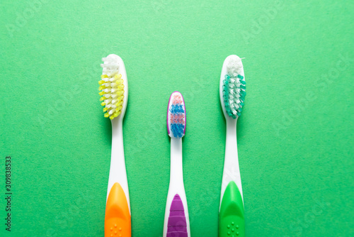 plastic colored toothbrushes on green background © Pavel