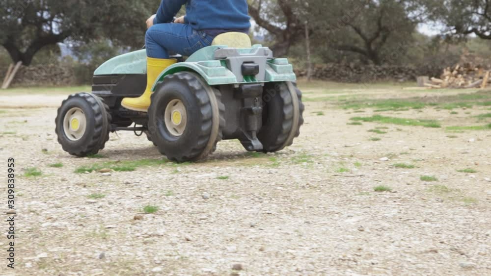unrecognizable child playing with a toy tractor in the field unrecognizable child playing with a toy tractor in the field