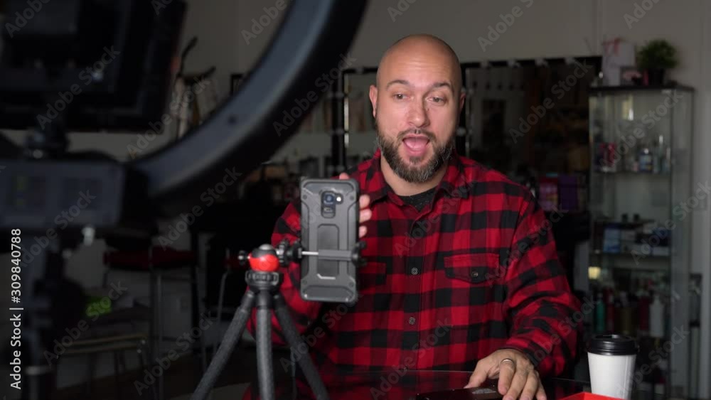 man blogger is recording a video message to his subscribers with a coffee mug in his hand man blogger is recording a video message to his subscribers with a coffee mug in his hand