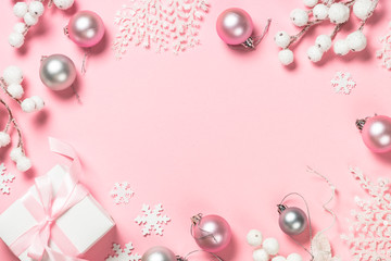 Christmas present box and decorations on pink background.