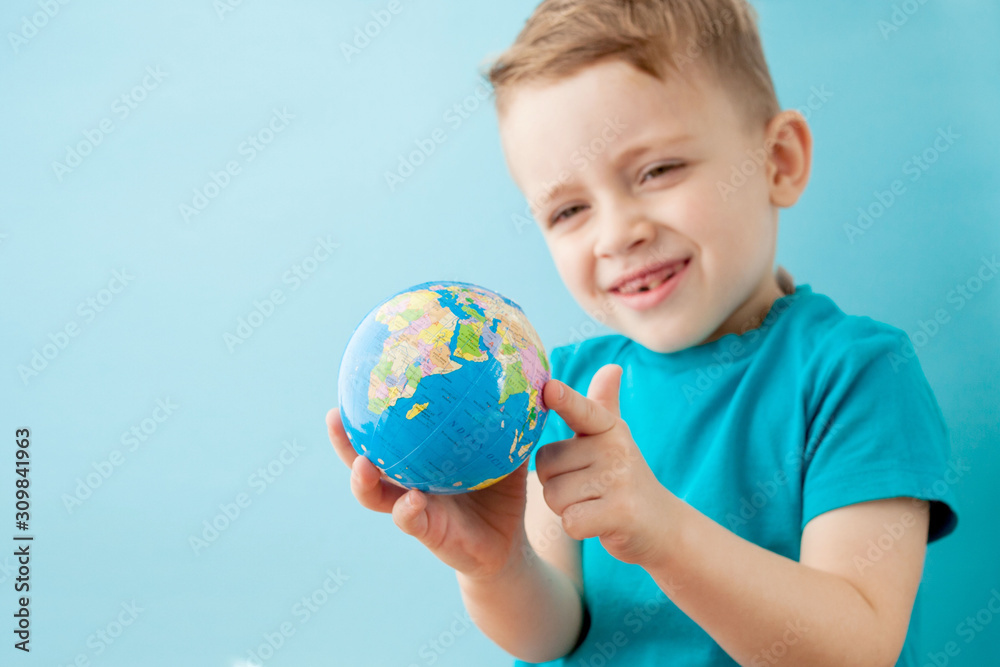 Little boy holding a globe on blue background Little boy holding a globe on blue background