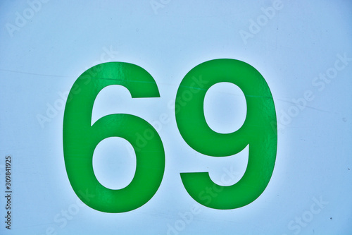 A house number plaque, showing the number sixty nine (69) photo