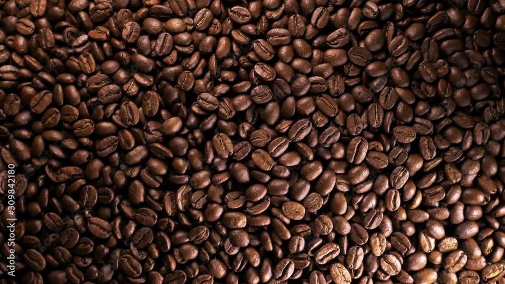 Roasted coffee bean. Fragrant coffee beans scrolls slowly around the camera. Slow Motion Close Up of Whole Roasted Coffee Beans. Roasted coffee bean. Fragrant coffee beans scrolls slowly around the camera. Slow Motion Close Up of Whole Roasted Coffee Beans.