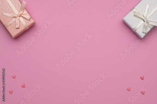 ....Romantic concept for Valentine`s Day. Flat lay. Pattern of pink hearts on a pink background and peach color and white gift box.  Copy Space. © MIKHAIL