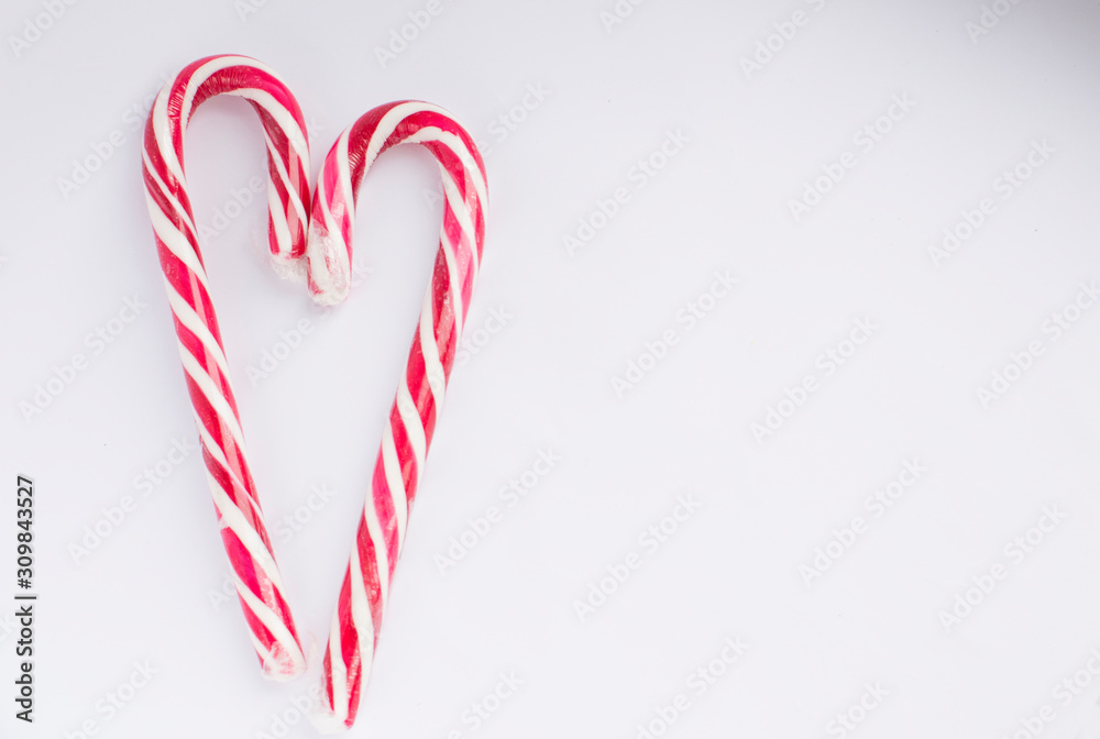 Naklejka premium Christmas candy on a white background in the form of a heart, with free space for writing