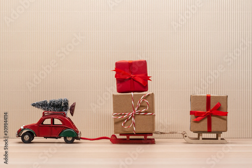Fototapeta christmas red toy car with sledges gift fir-tree