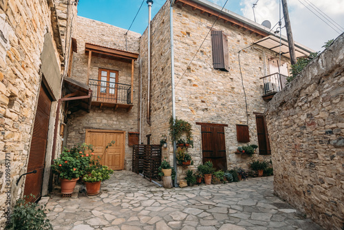 Fototapeta Naklejka Na Ścianę i Meble -  Beautiful narrow street of Lefkara village, Cyprus with flower pots and masonry.