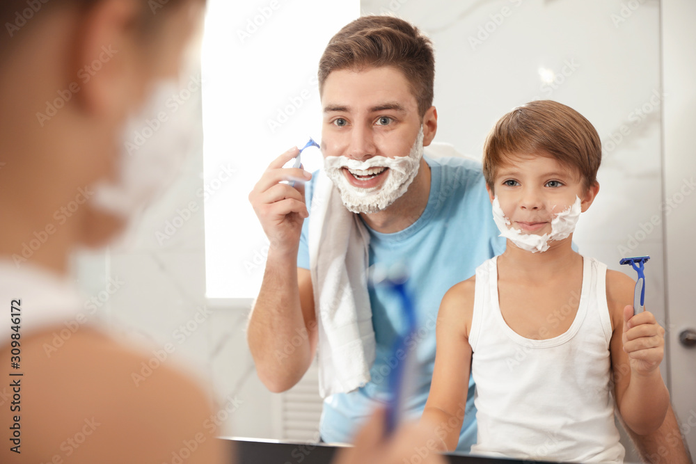 Dad shaving and son imitating him in bathroom Dad shaving and son imitating him in bathroom